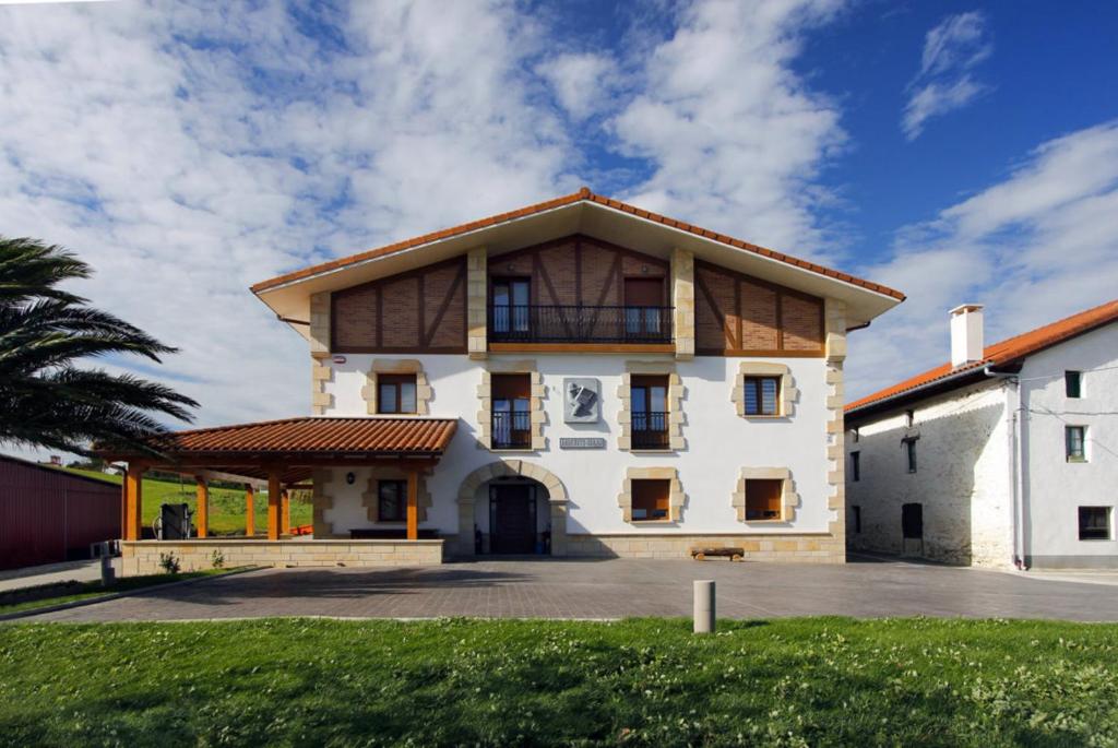 una gran casa blanca con techo de gambrel en Endaneta Berri, en Zumaia