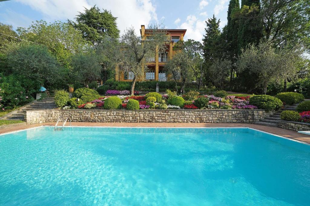 ガルドーネ・リヴィエラにあるVilla Vibe Luce, beautiful period villa with private pool and lake viewの庭園付きの家の前のスイミングプール