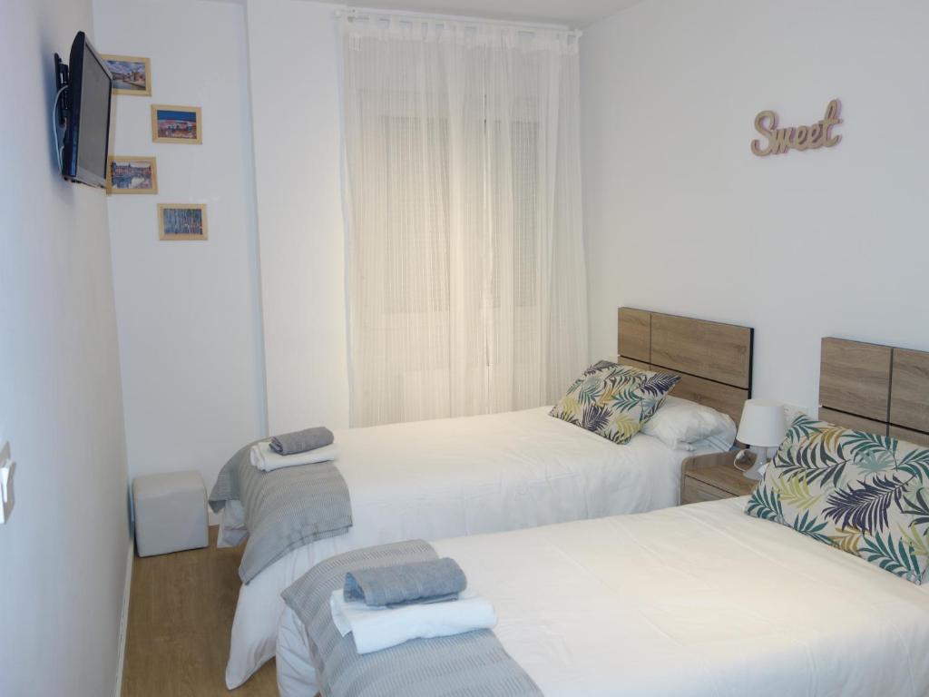 een hotelkamer met 2 bedden en een televisie bij La Concordia in Bilbao
