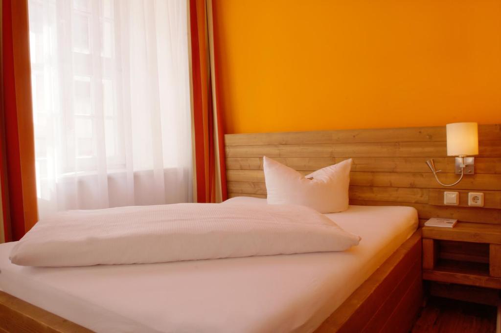 Postel nebo postele na pokoji v ubytování Hotel Am Obermarkt