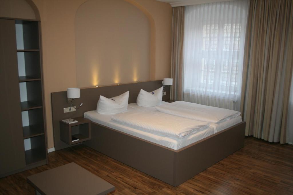 Postel nebo postele na pokoji v ubytování Hotel Am Obermarkt