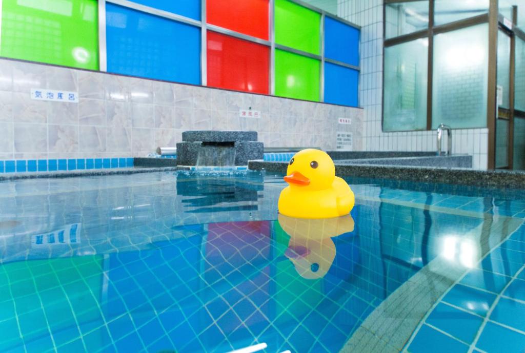 un pato amarillo de goma sentado en una piscina en Guesthouse Mokumoku, en Osaka