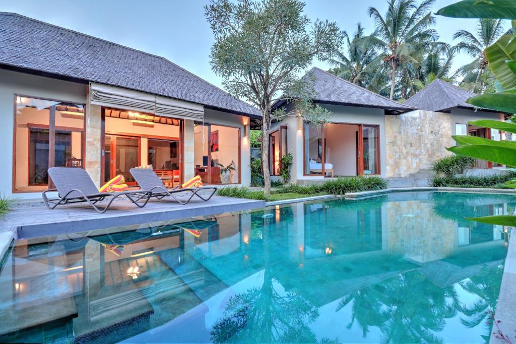 - une vue sur l'extérieur d'une maison avec une piscine dans l'établissement Villa Aprikot Ubud, à Ubud