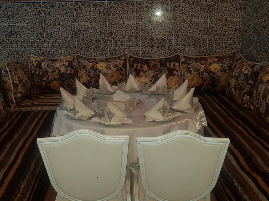 a table and chairs in a room with a couch at Dar Merzouga Meknes in Meknès