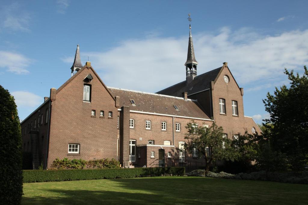 a large brick building with a clock on the front of it at Het Klooster Breda in Breda