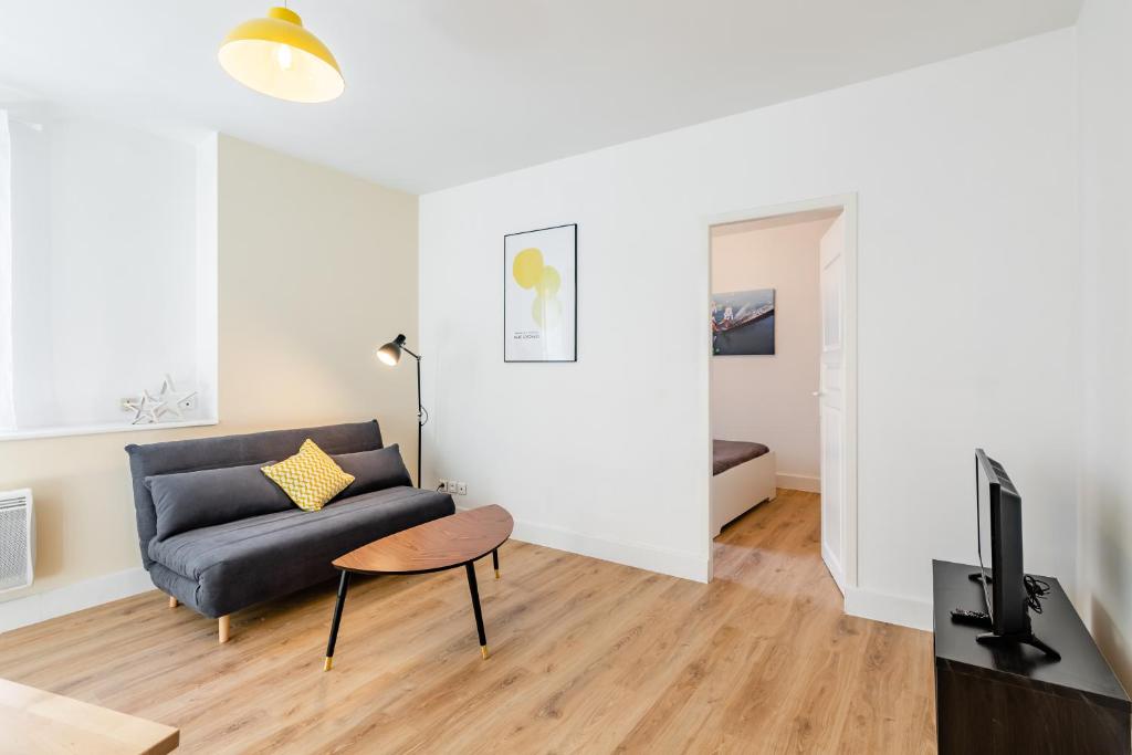 ein Wohnzimmer mit einem Sofa und einem Tisch in der Unterkunft Maison de ville pour 4 personnes in Marseille