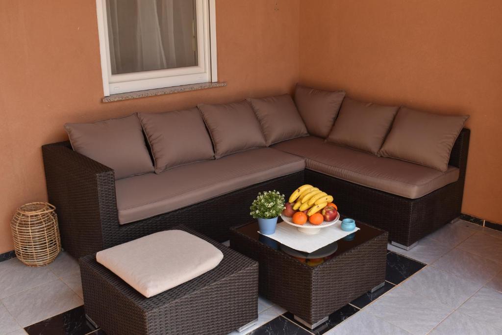 ein Wohnzimmer mit einem Sofa und einer Obstschale in der Unterkunft Holiday house Matej in Vir