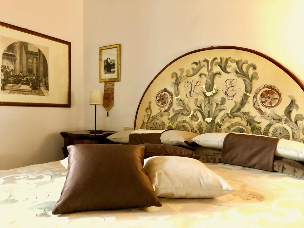 a bedroom with two beds and a large headboard at Agriturismo Podere Pescara in Orvieto
