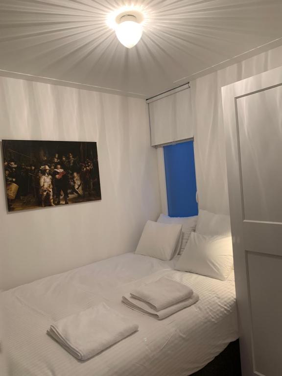 ein weißes Bett mit zwei gefalteten Handtüchern darauf in der Unterkunft Kangaroom in Amsterdam