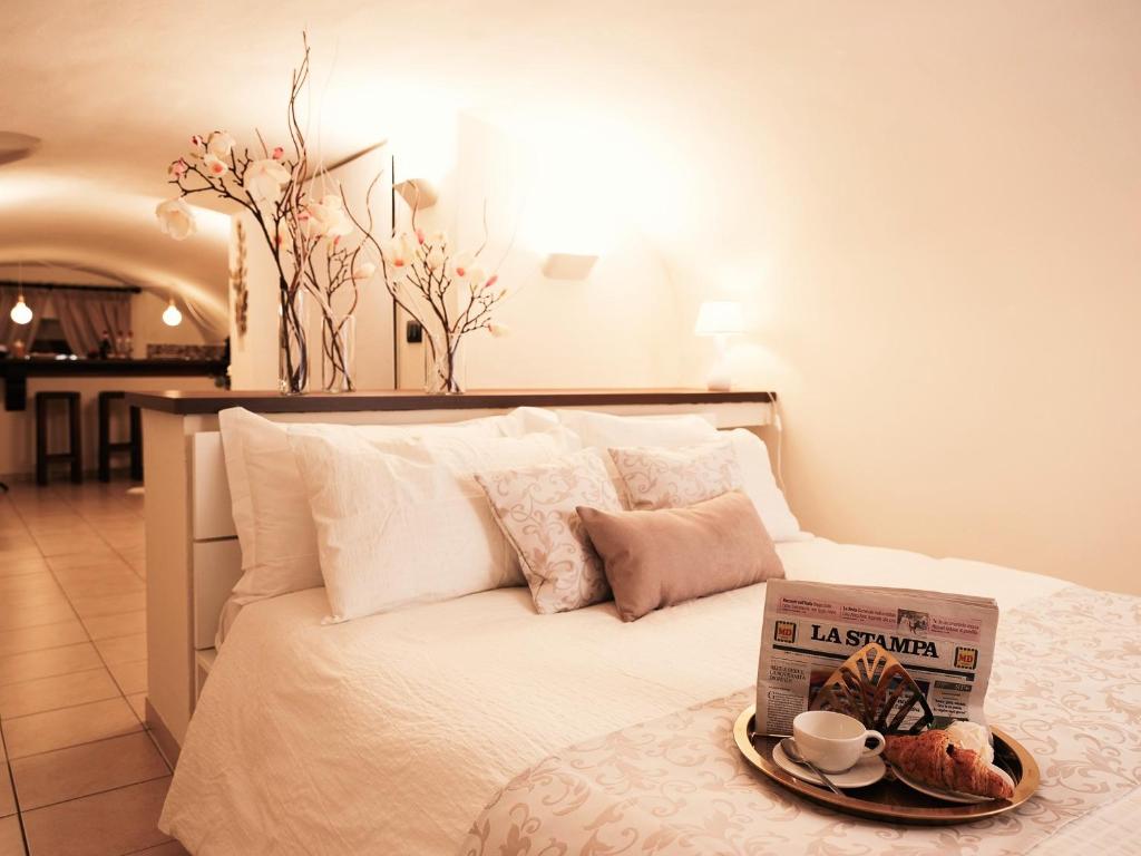 ein Bett mit einem Teller Essen und einem Buch darauf in der Unterkunft Suite San Domenico in Turin