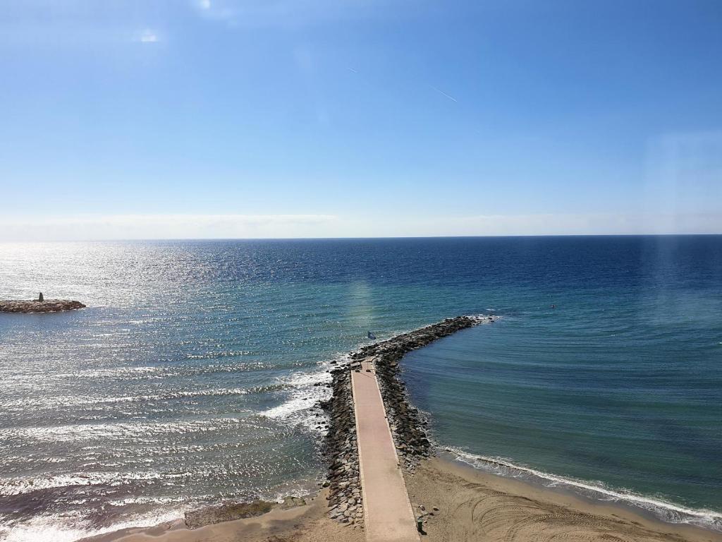 un muelle se extiende hacia el océano en una playa en Skol 617 Beachfront Two-bedrooms Duplex With Sea Views, en Marbella