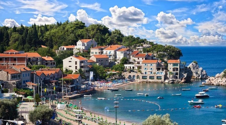 a town with boats in a body of water at ZEN Apartment Pržno in Sveti Stefan