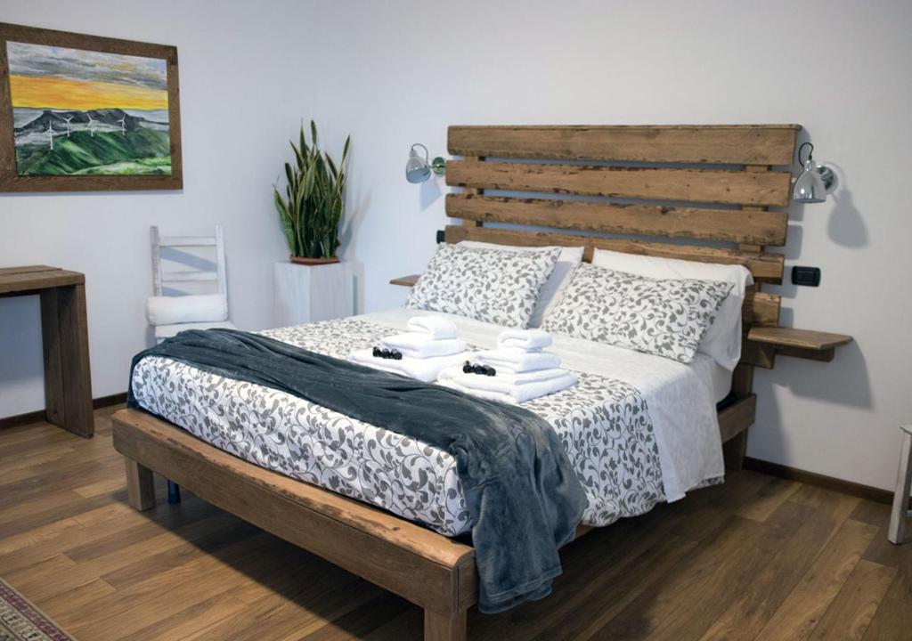 Rivoli VeroneseにあるB&B Casa Zuaneのベッドルーム1室(木製ヘッドボード付きのベッド1台付)
