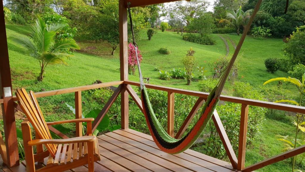 a porch with a swing and a chair at Hotel Finca Maresia in Drake