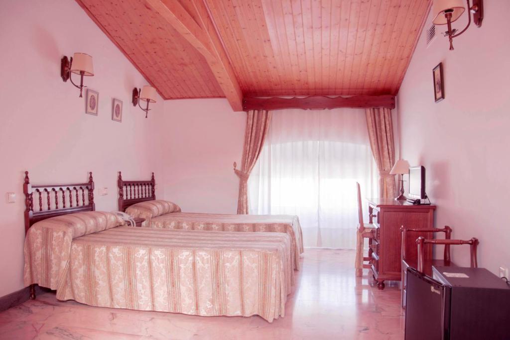 a bedroom with two beds and a large window at Victoria in Trujillo