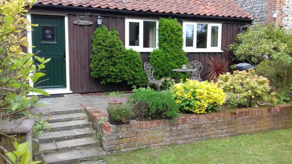 une maison avec une porte verte et quelques plantes dans l'établissement Thorpegate Cottage, à Thorpe Market