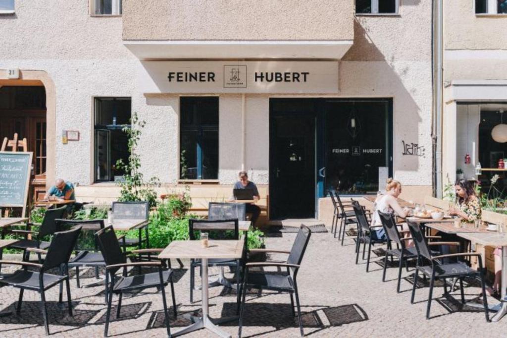 a group of tables and chairs in front of a store at Cosy flat in trendy Sprengelkiez (legal) in Berlin