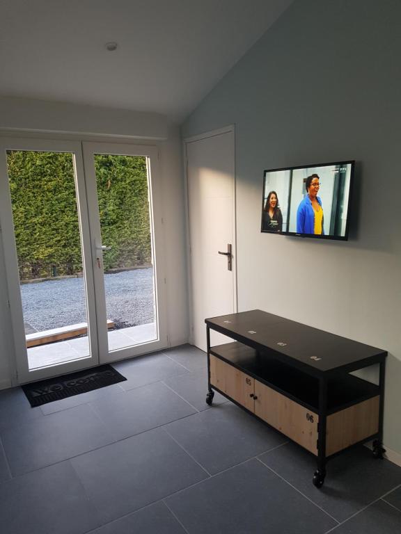 uma sala de estar com televisão na parede em gîte Lemarocha em Groffliers