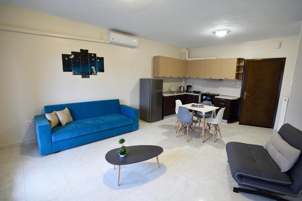 a living room with a blue couch and a table at San Giorgio Luxury Apartments in Ierissos