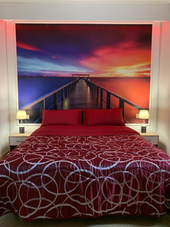 1 dormitorio con 1 cama y una pintura de un muelle en The lux, en Adrano