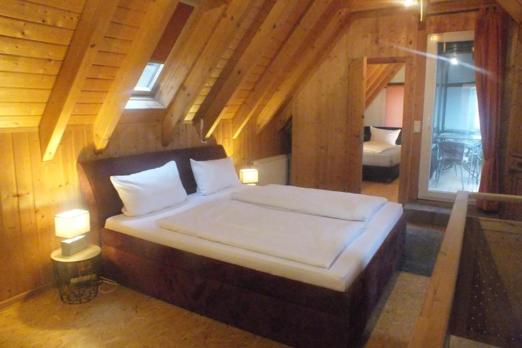 Cette chambre en bois comprend un grand lit. dans l'établissement Rheinufer-Lodge in Leverkusen-Hitdorf-mit Blick auf den Rhein - Zentral an der A1 und der 59, à Leverkusen