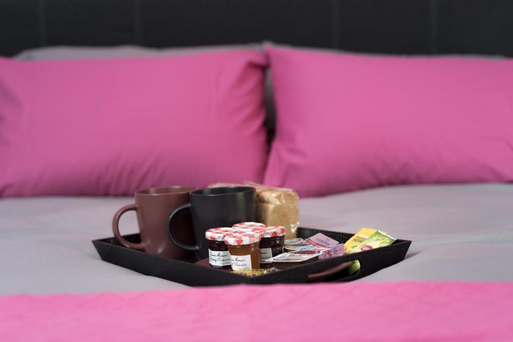 a tray with two coffee cups andocolates on a bed at Tonias house in Athens in Athens