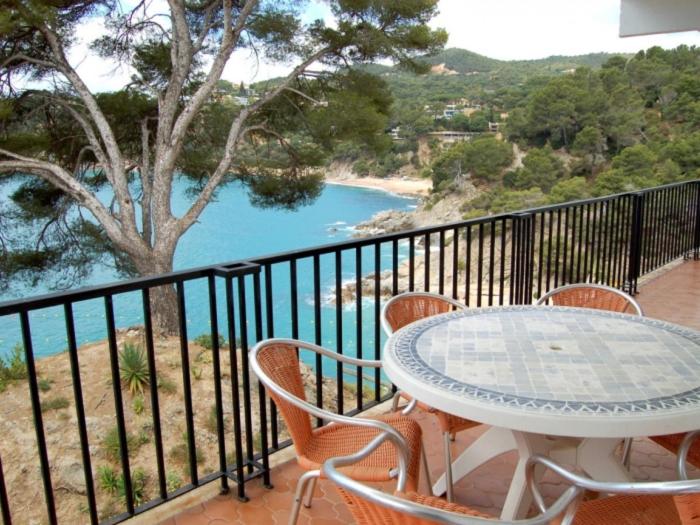 einen Tisch und Stühle auf einem Balkon mit Blick auf das Wasser in der Unterkunft Appartement FRONT de MER in Tossa de Mar