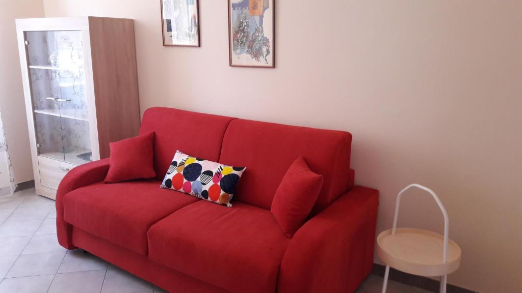 een rode bank in een woonkamer bij Appartamento Centrale con garage in Asti