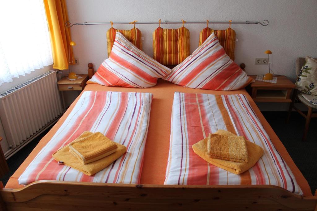 a bed with two pillows and two towels on it at Pension Haus Thies in Cochem