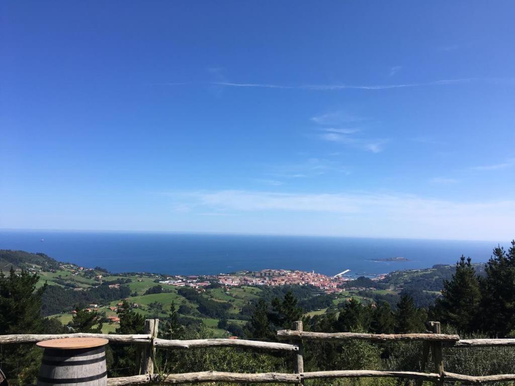 widok na ocean z wzgórza z płotem w obiekcie APARTAMENTOs URDAIBAI 2 w mieście Bermeo
