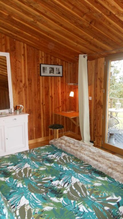 een slaapkamer met een groot bed in een houten kamer bij Domaine de Sault in Dore-lʼÉglise