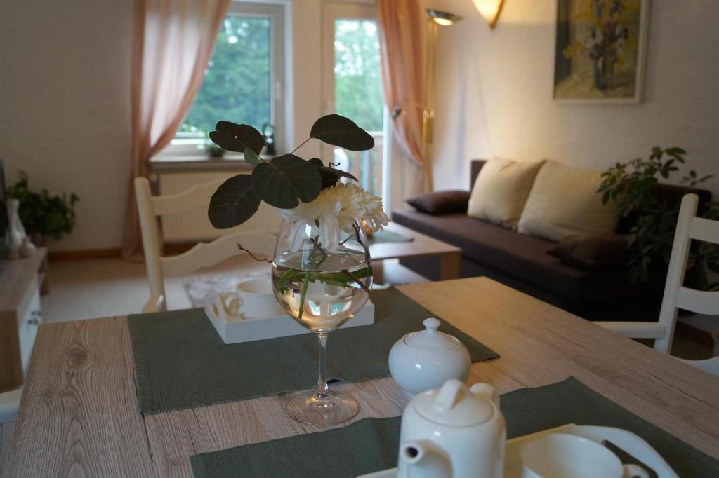 einen Esstisch mit einer Blumenvase darauf in der Unterkunft Ferienwohnung Shamrock in Hahnenklee-Bockswiese