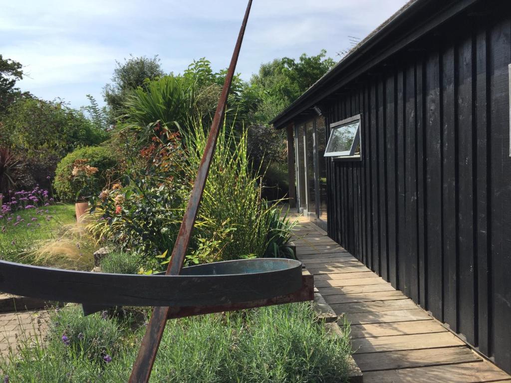 a garden with a large boat in the yard at The Studio @ Aubrey Cottage in Chichester