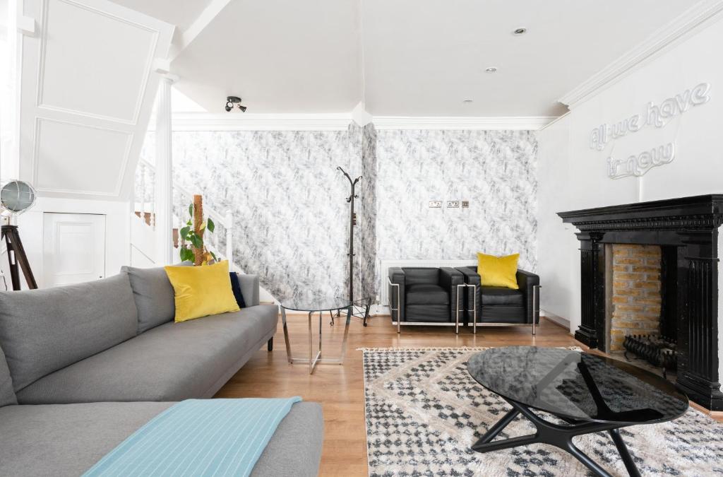 un soggiorno con divano e camino di The Paddington Mews - Comfortable & Elegant 3BDR Paddington Mews a Londra