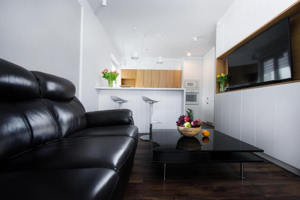 a living room with a couch and a bowl of fruit on a table at Apartament Rynek22 in Kazimierz Dolny