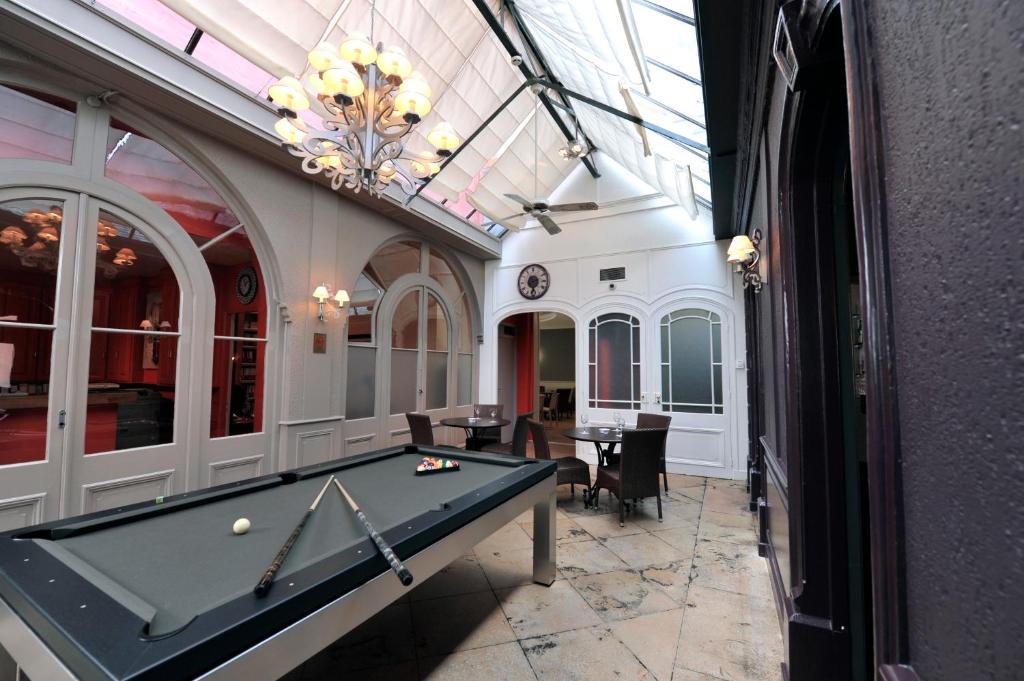 uma sala de bilhar com uma mesa de bilhar em LOGIS Hôtel de Bourgogne - Mâcon em Mâcon