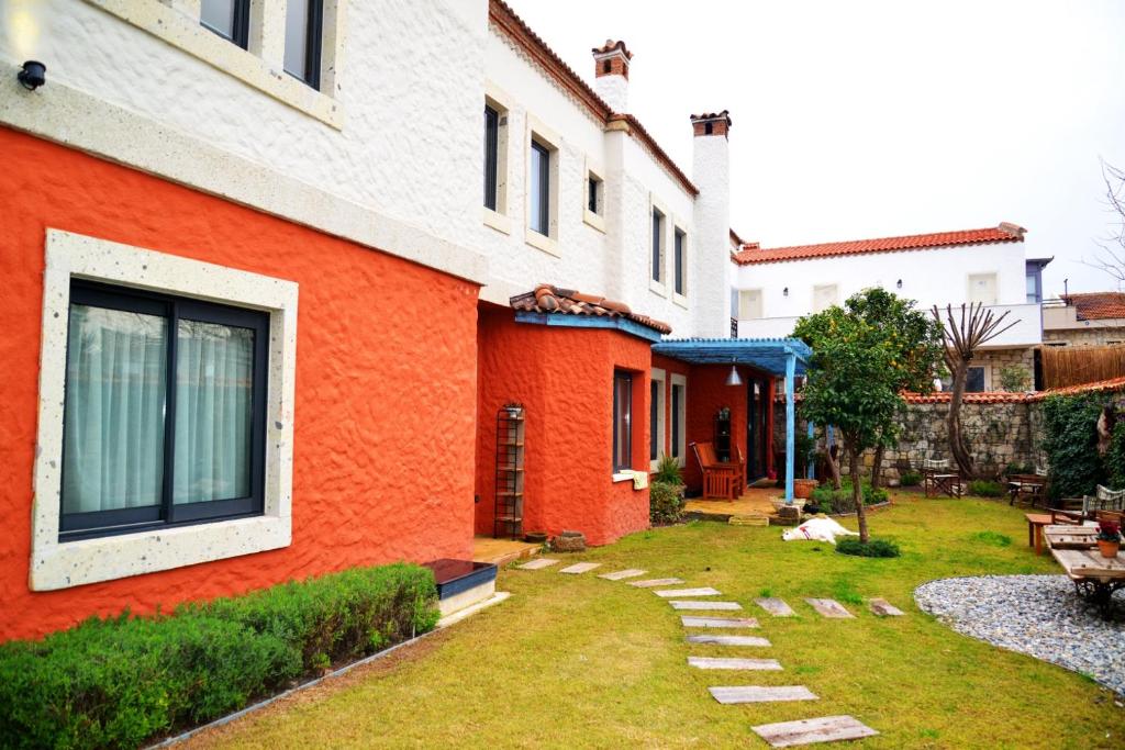 una casa arancione e bianca con cortile di Alacati Suites ad Alaçatı