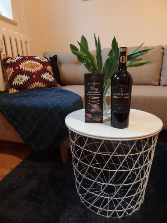a bottle of wine on a table in a living room at Apartament Ducha NO'7 in Toruń