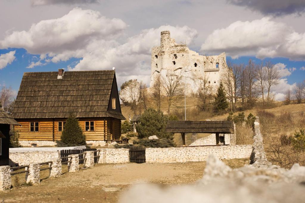 Chata w Mirowie في Mirów: قلعة قديمة على تلة مع منزل