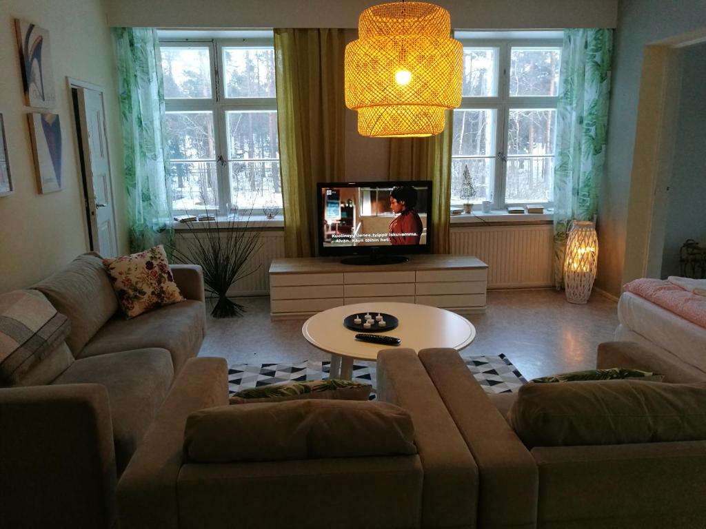 - un salon avec un canapé et une télévision dans l'établissement Kotkan Residenssi Apartments, à Kotka