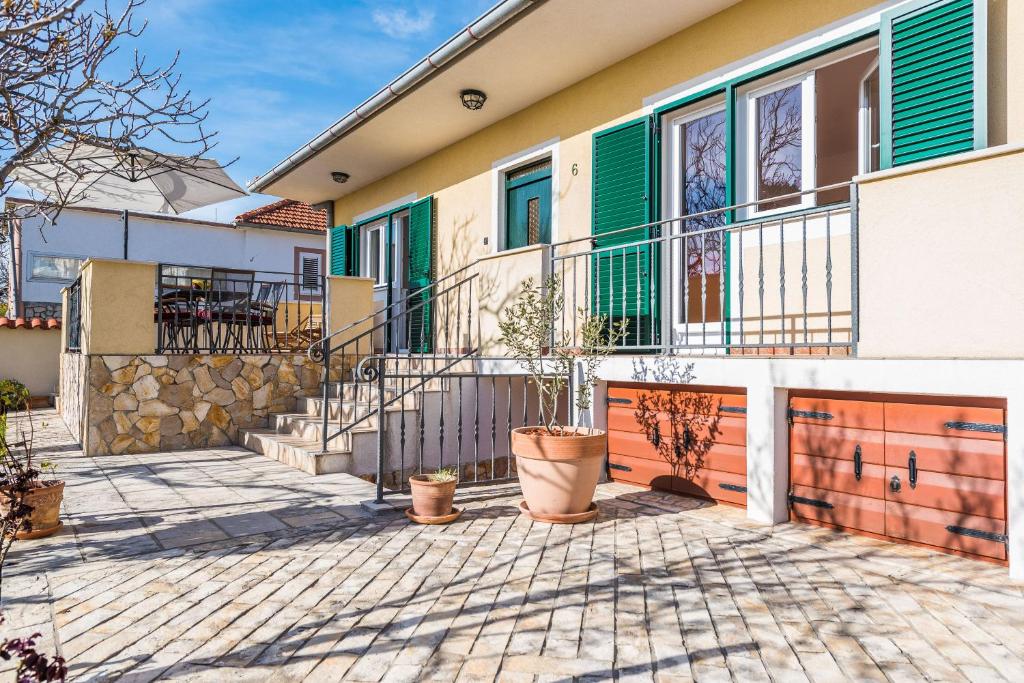 a house with a balcony and potted plants in front of it at Holiday House Lavanda in Vrsi