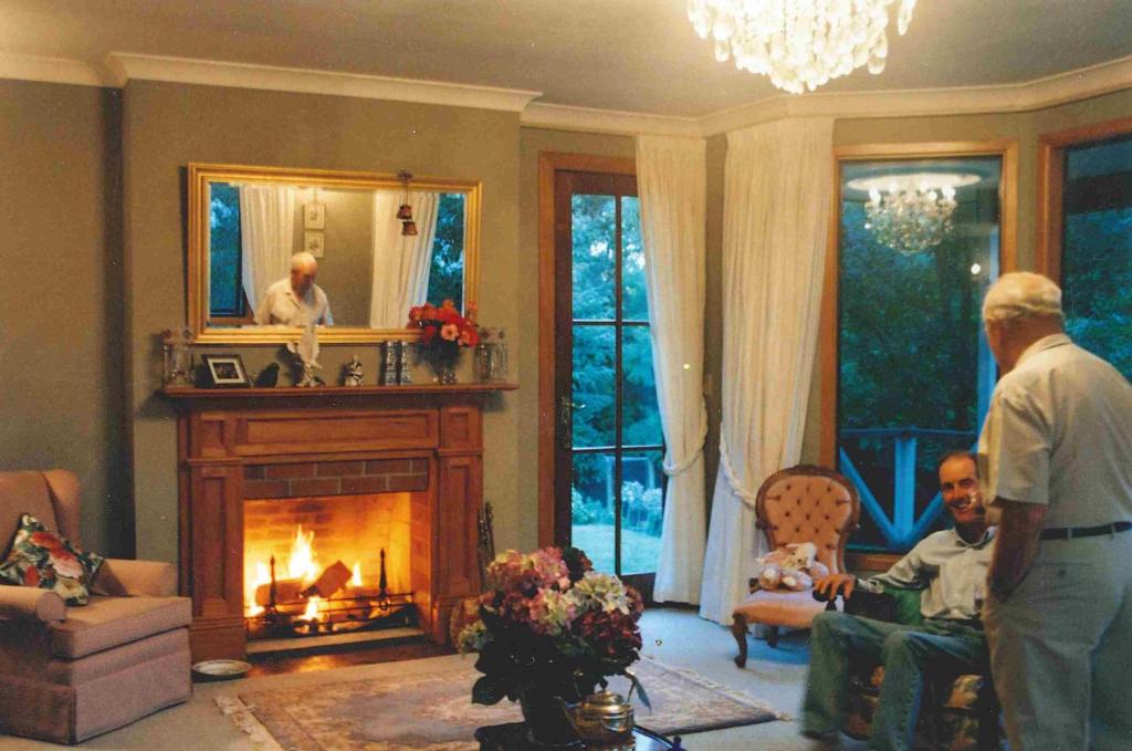 a man standing in a living room with a fireplace at TWYNHAM at Kinloch in Kinloch