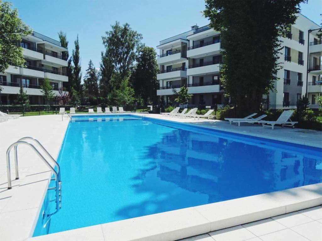 a large swimming pool in front of a building at Apartamenty Waterline Ustronie Morskie in Ustronie Morskie