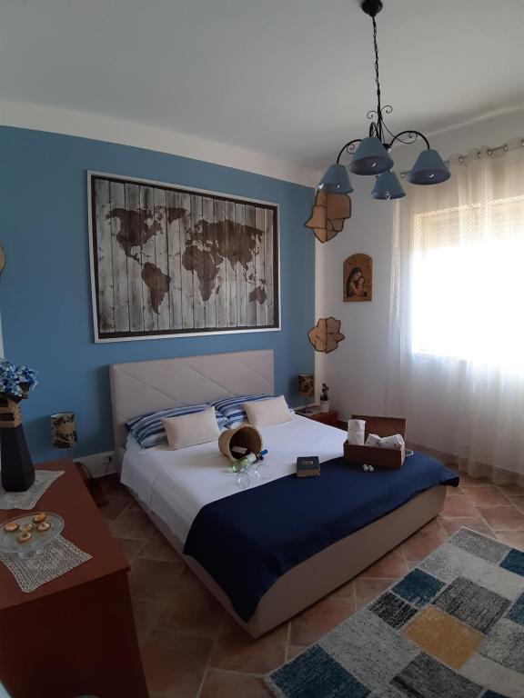 a bedroom with a large bed with a blue wall at Casa Luce in Caltabellotta