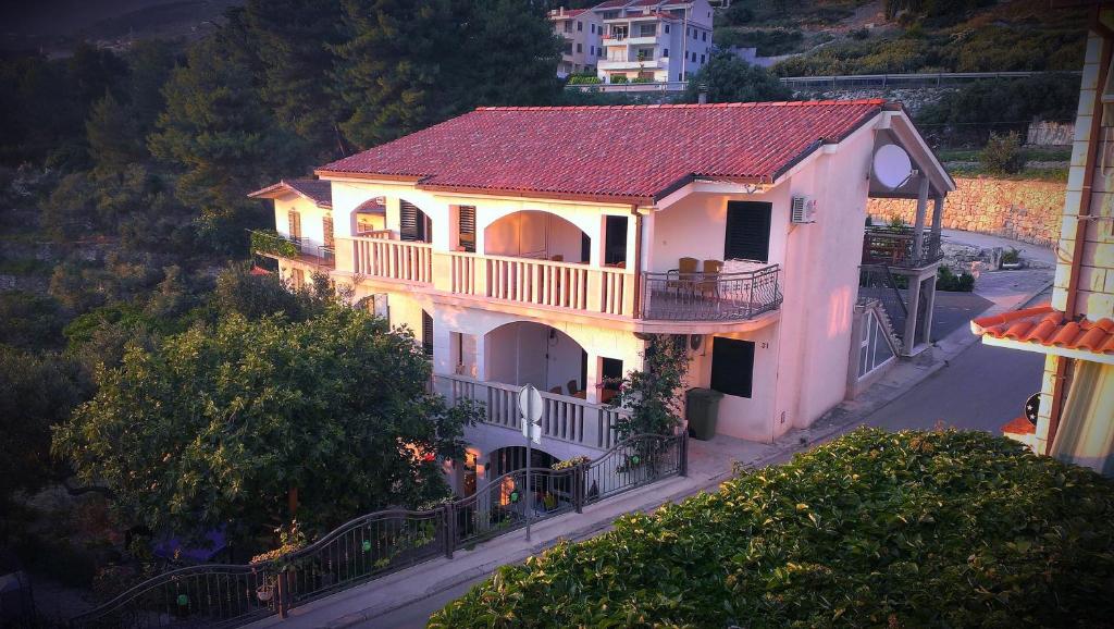 une maison blanche avec un toit rouge dans une rue dans l'établissement Apartments Anamarija, à Makarska