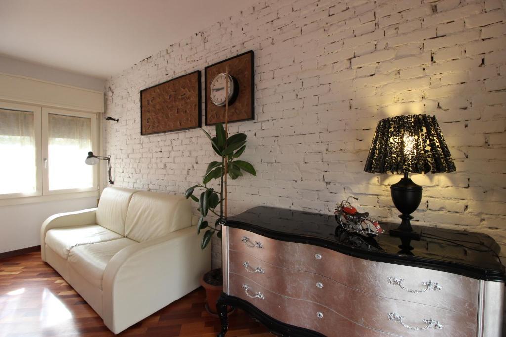 un soggiorno con divano e tavolo con lampada di CASA-MIA Apartment a Mestre