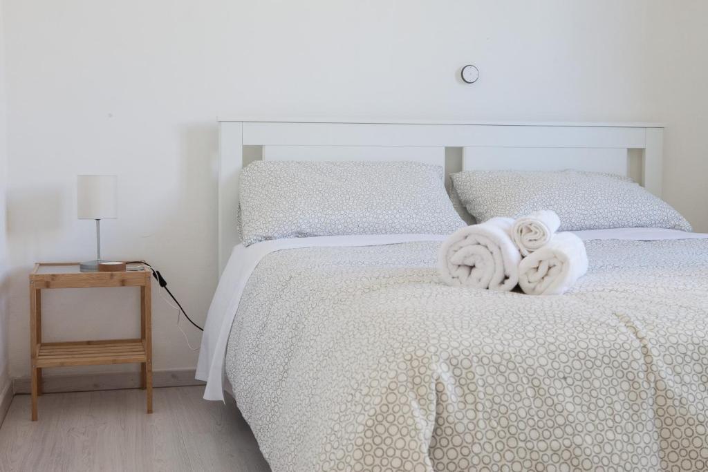 a bedroom with a white bed with towels on it at Cleo Giglio in Ancona