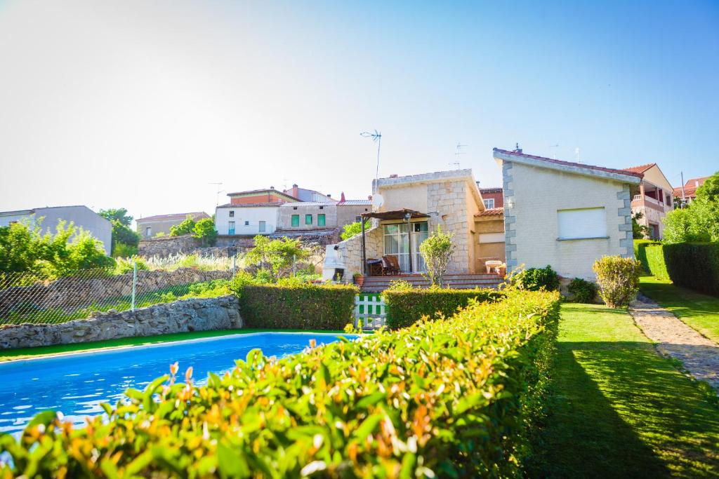 Villanueva de Ávila的住宿－Los Chendas，庭院中带游泳池的房子