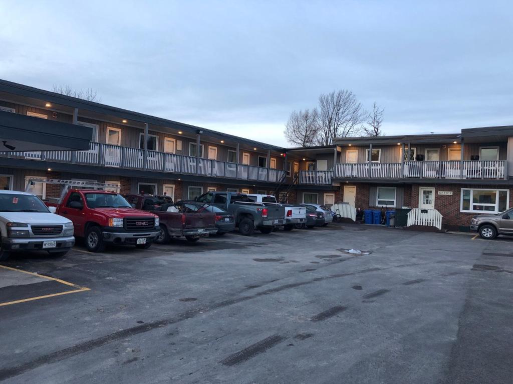 a parking lot with several cars parked in front of it at All Seasons Motel in Port Elgin