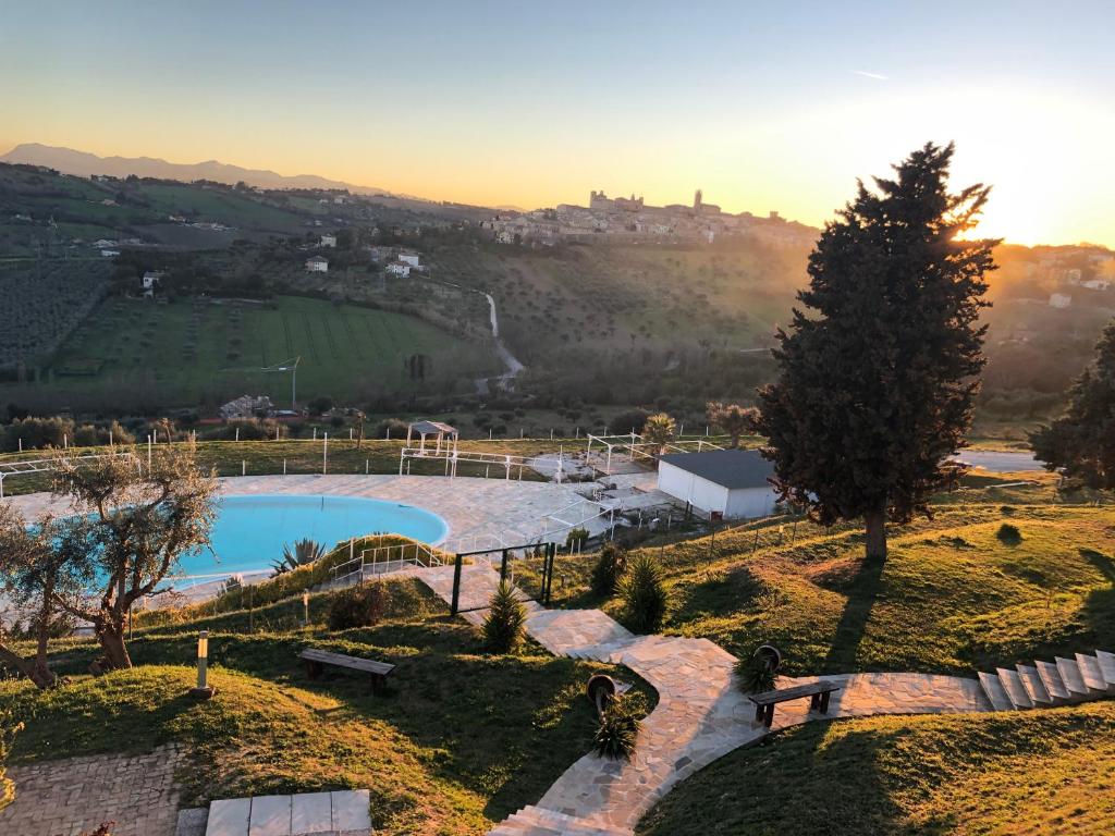uma vista para uma piscina numa colina com uma árvore em Casablanca Hotel em Civitanova Marche